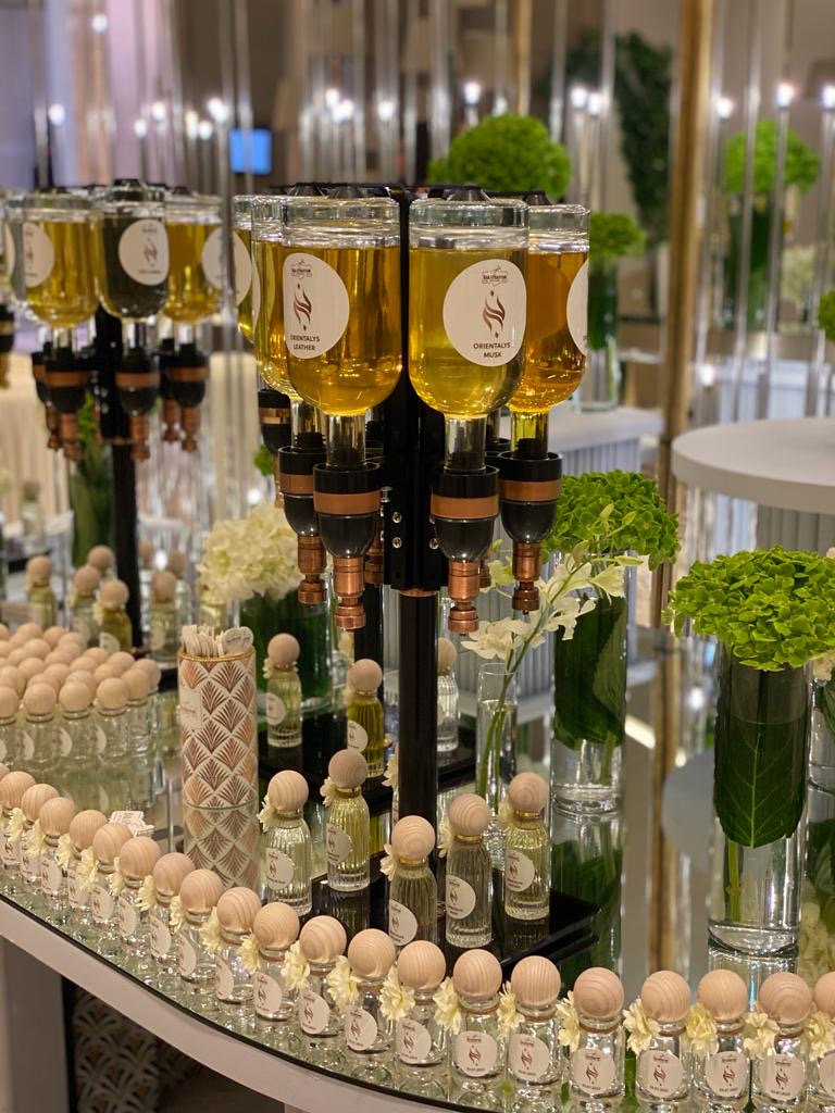 Perfume dispensers and perfume bottles with white flowers.
